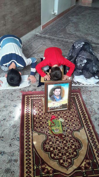نماز خواندن سه فرزند شهید محسن فرامرزی پشت عکس پدر 